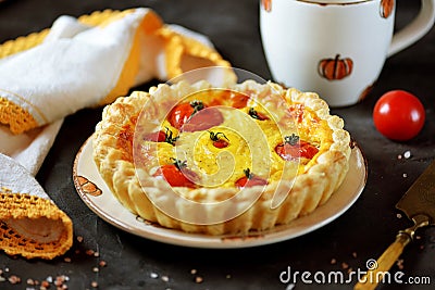 Tart pie with cheese, eggs, cream and cherry tomatoes on puff pastry. Stock Photo