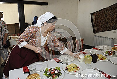 At the Tartar restaurant: waitress in Tartar native dress setting the table Editorial Stock Photo