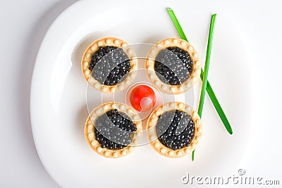 Tartlet with black caviar on a white platter Stock Photo