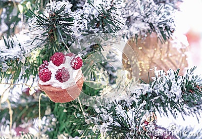 Tartlet with butter cream and raspberries on a snow-covered Christmas tree Stock Photo