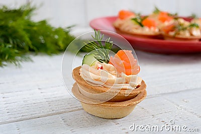 Tartlets with cream cheese and salted salm on a white wooden background. Tasty light snack for a party. Stock Photo