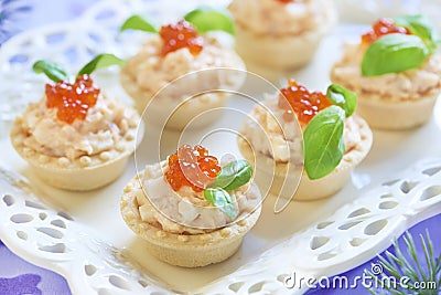 Tartlets with seafood salad, red caviar and basil Stock Photo