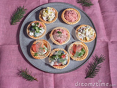 Tartlets with various salads on a large ceramic dish. Stock Photo