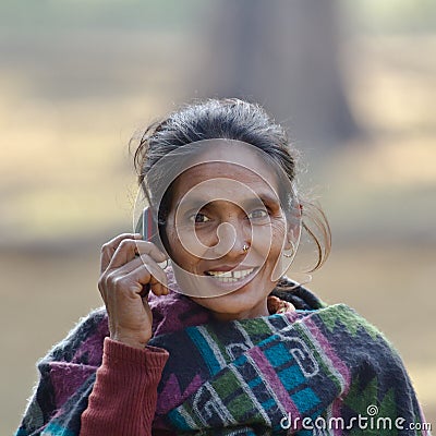 Taru ethnic woman talking with mobil phone in Nepal Editorial Stock Photo