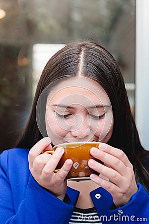 Taste of Serenity: Close-Up of a Latin Young Woman Enjoying a Scrumptious Coffee at the Outdoor Patio of a Cozy Cafe Stock Photo