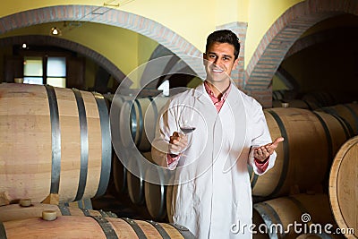 taster of winery with wine in cellar. Stock Photo