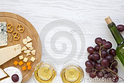 Tasting cheese with wine, grapes, walnuts and pretzels on wooden background. Food for romantic. From above. Top view. Flat lay. Stock Photo