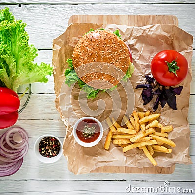 Tasty american hamburger with beef and french fries on wood background. Top view. Flat lay. Stock Photo