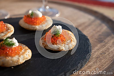 Tasty appetizer for dinner, small pancakes bliny with red fish caviar Stock Photo