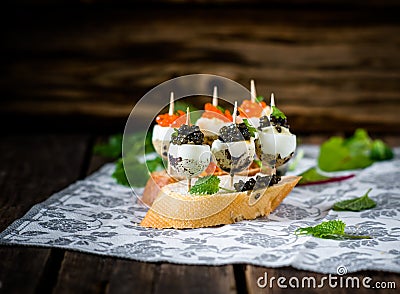 Tasty appetizer of quail eggs with red and black caviar. Stock Photo