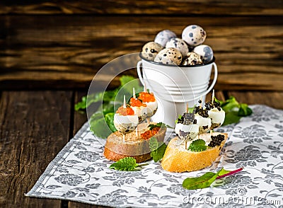 Tasty appetizer of quail eggs with red and black caviar. Stock Photo