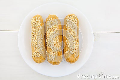 Tasty appetizing french eclairs on a white plate on white background Stock Photo