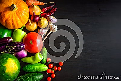 Tasty appetizing fresh autumn seasonal vegetables on dark wooden background top view with copy space. Healthy food, vegetarianism Stock Photo