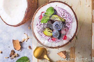 Tasty appetizing smoothie acai bowl made from blackberries and wild berries. Served in coconut bowl. Healthy life clean eating con Stock Photo