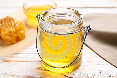 Tasty aromatic honey in glass jar on wooden table Stock Photo