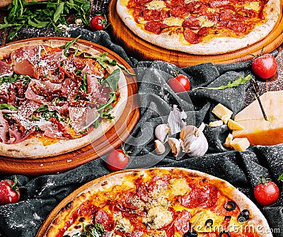 Tasty assorted three pizzas on a wooden boards Stock Photo