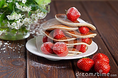 Tasty, only baked pancakes with strawberries on a dark surface, homemade cakes Stock Photo