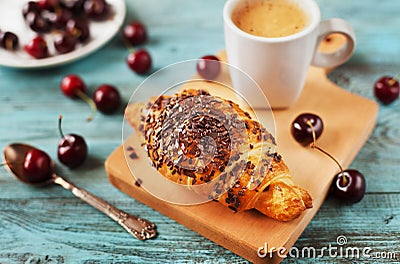 Tasty breakfast with fresh croissant, coffee and cherries on a wooden table Stock Photo