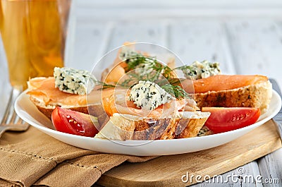 Tasty breakfast. Sandwiches with salmon and cheese and cherry tomatoes on a wooden white Stock Photo