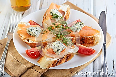 Tasty breakfast. Sandwiches with salmon and cheese and cherry tomatoes on a wooden white Stock Photo
