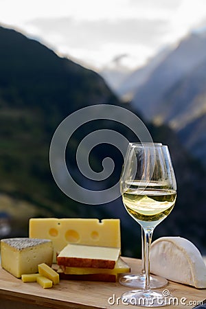 Tasty cheese and wine from Savoy region in France, beaufort, abondance, emmental, tomme and reblochon de savoie cheeses and glass Stock Photo
