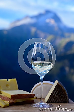 Tasty cheese and wine from Savoy region in France, beaufort, abondance, emmental, tomme and reblochon de savoie cheeses and glass Stock Photo