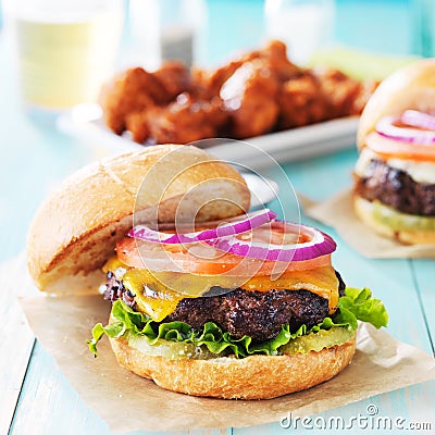 Tasty cheeseburgers with wings and beer Stock Photo