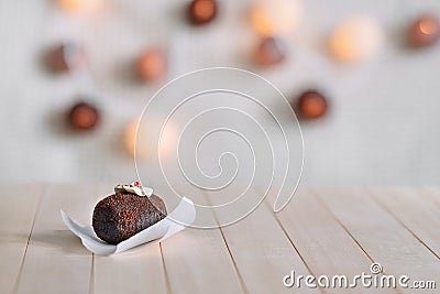 Tasty chocolate cake on a wooden natural background. Top decorated with cream and a piece of jelly. In the background glow round l Stock Photo