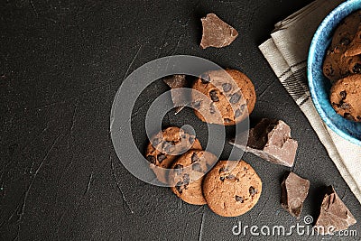 Tasty chocolate chip cookies on dark background, flat lay. Stock Photo