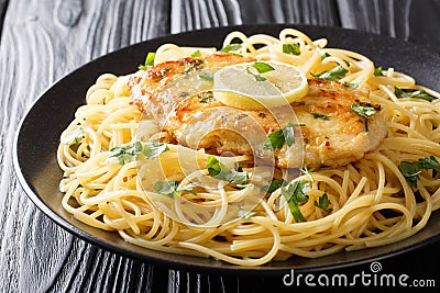 Tasty classic chicken Francaise with spaghetti in lemon wine sauce close-up on a plate. horizontal Stock Photo