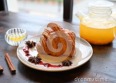 Tasty classic croissant with sea buckthorn teaa Stock Photo