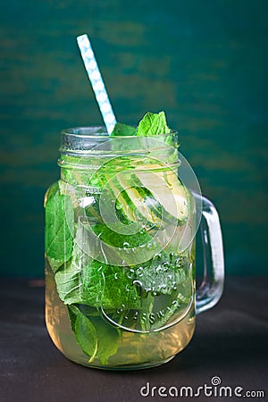 Tasty colourful drink with cold green tea, mint and cucumber in a glass jar on a vintage background Stock Photo