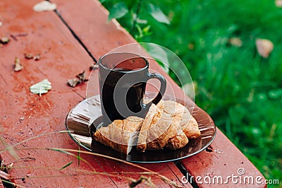 Tasty croissants with hot coffee on the bench Stock Photo