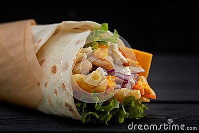 Tasty doner kebabs with fresh salad trimmings and shaved roasted meat served in tortilla wraps on brown paper as a Stock Photo