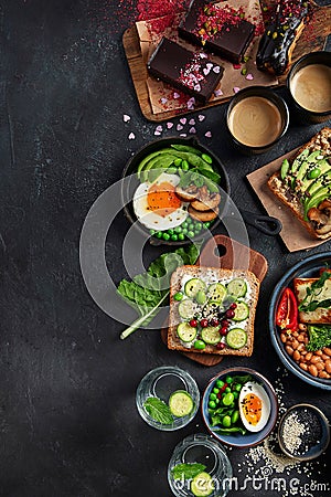 Tasty food with avocado toast, vegetables, eggs on dark background. Helthy breakfast concept Stock Photo
