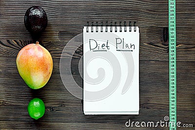 Tasty food for slimming. Notebook for diet plan and fruits on wooden table top view mock up Stock Photo