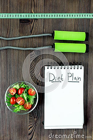 Tasty food for slimming. Notebook for diet plan, salad and fruits on wooden table top view mock up Stock Photo