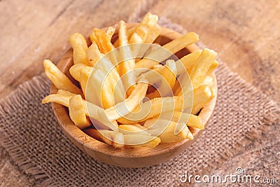 Tasty french fries in wooden bowl on burlap napkin Stock Photo