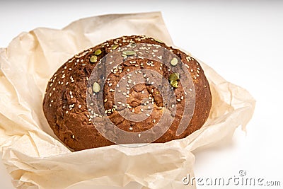 Tasty fresh baked loaf of dark bread with sesame seeds on white background Stock Photo