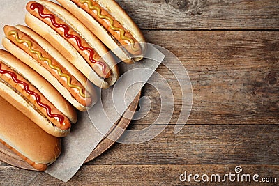 Tasty fresh hot dogs on wooden table, top view. Stock Photo