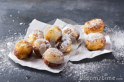 Closeupof deep fried cheese balls with powdered sugar on the baking paper, rustuc grey surface Stock Photo