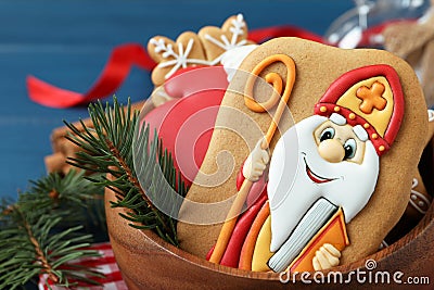 Tasty gingerbread cookies and fir branch in bowl, closeup. St. Nicholas Day celebration Stock Photo