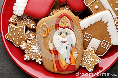 Tasty gingerbread cookies on red plate, top view. St. Nicholas Day celebration Stock Photo