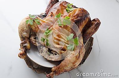 Tasty grilled chicken, parsley on plate and wooden cutting board,white marble table Stock Photo