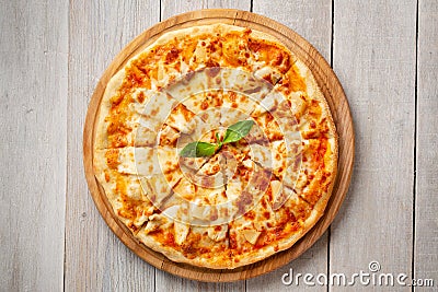 Tasty hawaiian pizza with chicken and pineapple on wooden cutting board. Top view Stock Photo