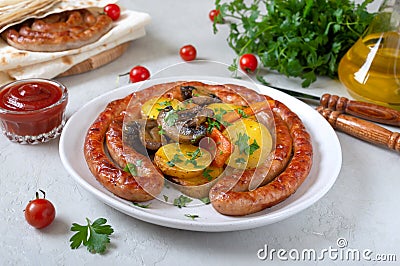 Tasty homemade grilled sausages with baked herb potatoes, mushrooms, cherry tomatoes and ketchup on a wooden background. Stock Photo