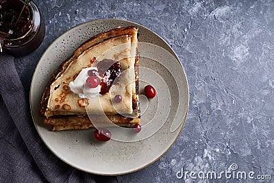 Tasty homemade pancakes with cranberries and sour cream served on gray stone table Copy space Top view Stock Photo