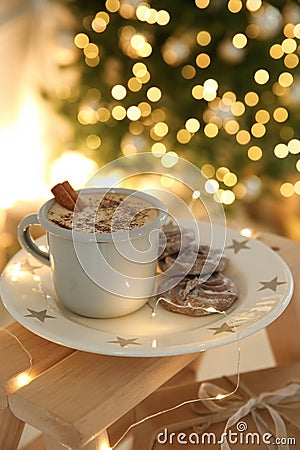 Tasty hot drink, cookies and Christmas lights in room Stock Photo