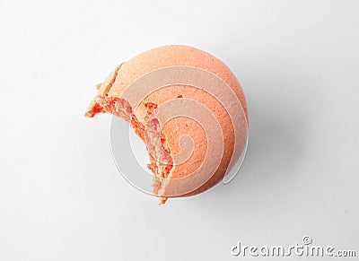 Tasty orange macaron with bite mark on white background Stock Photo