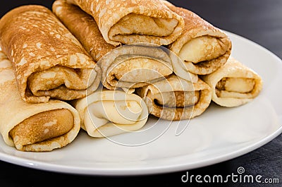 Tasty pancakes with cottage cheese in a white plate isolated on a black background. Close-up. Stock Photo
